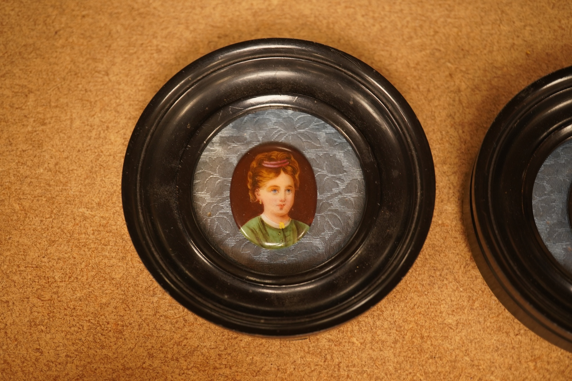 A pair of circular framed oval miniatures on porcelain plaques. Plaques 3.5cm high